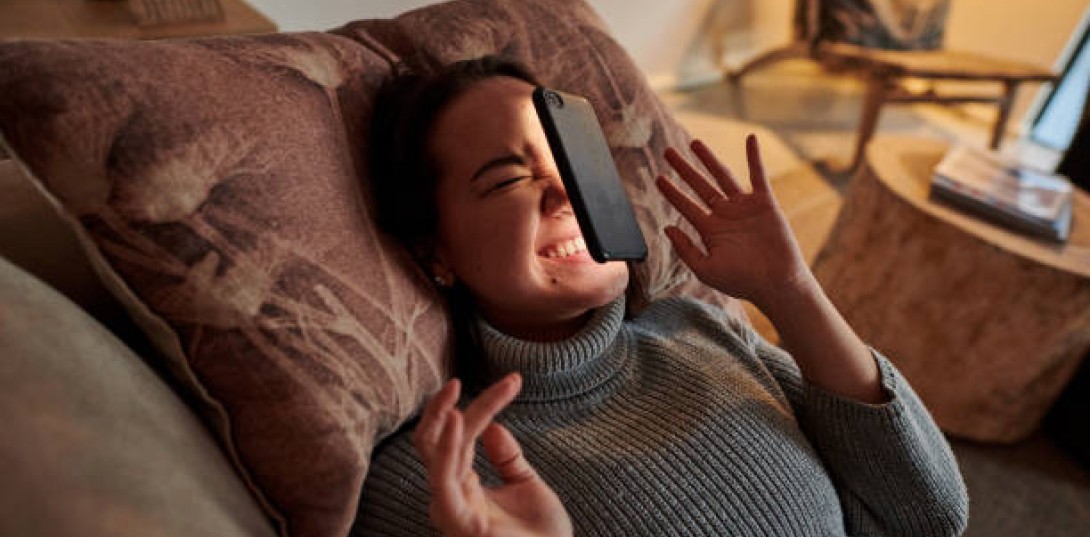 Kvinde taber telefon i hovedet som symbolik for ting, man ikke skal gøre under en jobsamtale